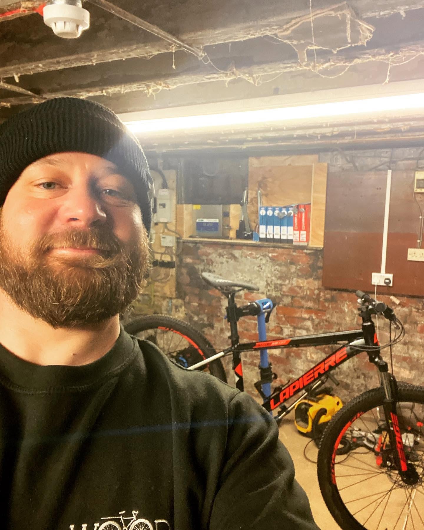 Matt in his workshop with a mountain bike on the repair stand