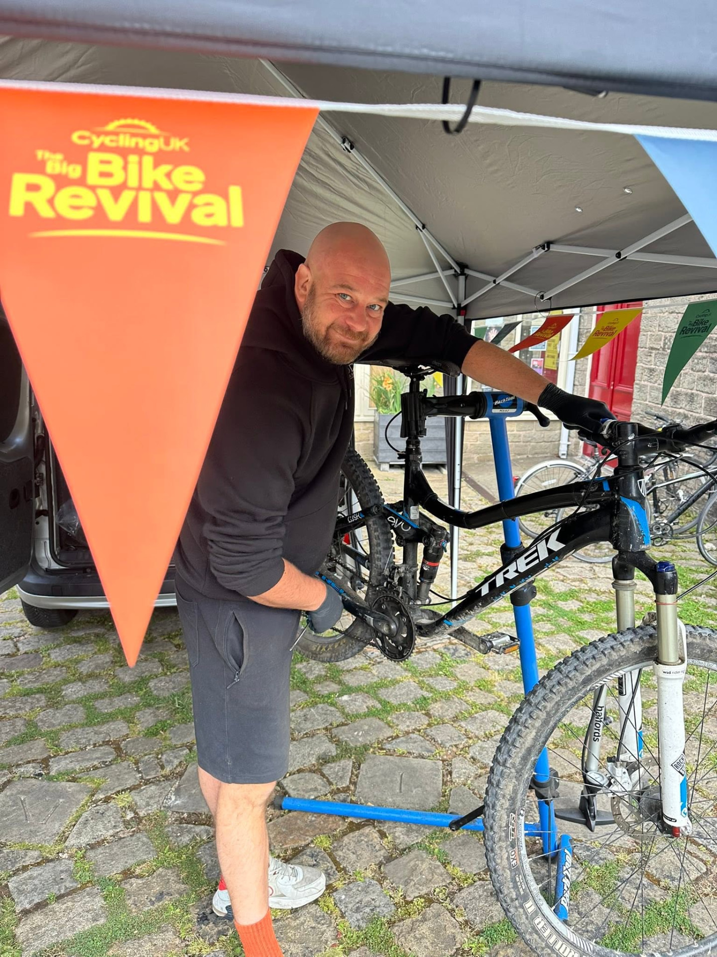 Matt repairing a Trek mountain bike at a community bike event
